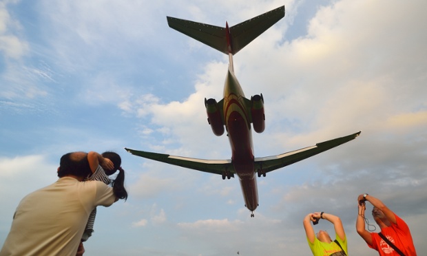 Aviation enthusiasts enjoy the sight of a landing airplane near the Songshan Airport in Taipei, Taiwan.
