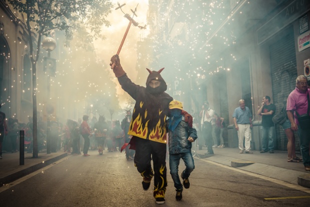 Children dance beneath fireworks during the Festa Major de Gracia