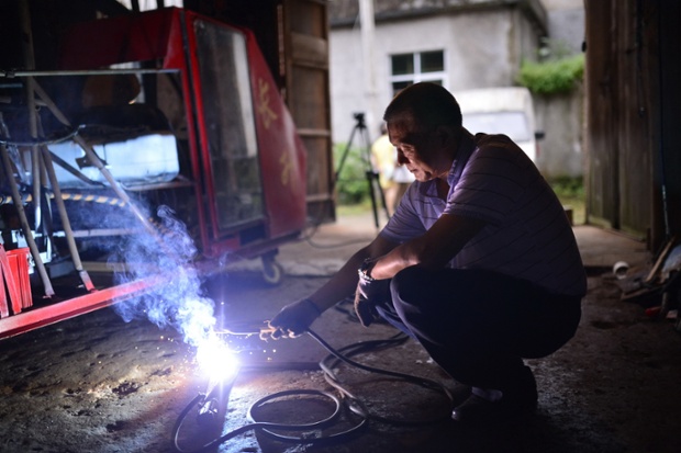 Jiang Changgen welds at his house in Nanchang, China. Jiang is a helicopter enthusiast who has been working on a homemade helicopter for 2 years