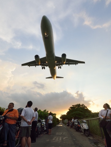 People watch a plane land near Songshan Airport in Taiwan