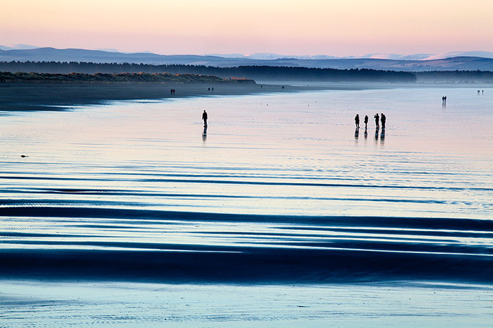 Enterprise beaches: Enterprise: Silhouetted figures on the West Sands, St Andrews, Scotland