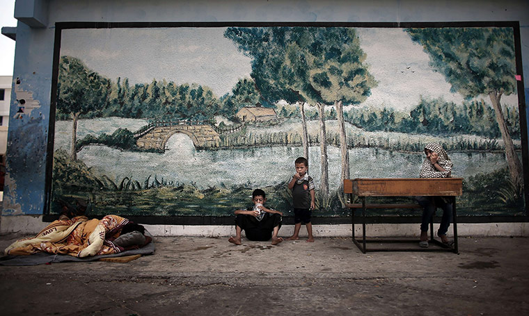 20 Photos: A Palestinian girl sits on a school desk at a UN school in Jabalia