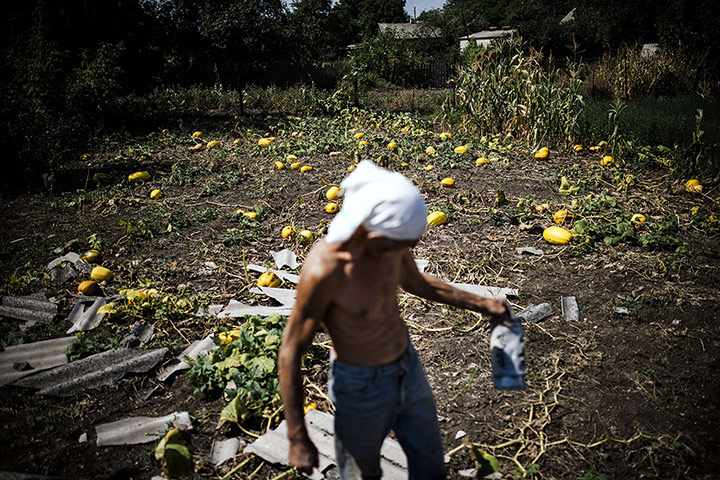 20 Photos: A man holds a piece of rocket shrapnel in his garden in Olenivka, Ukraine