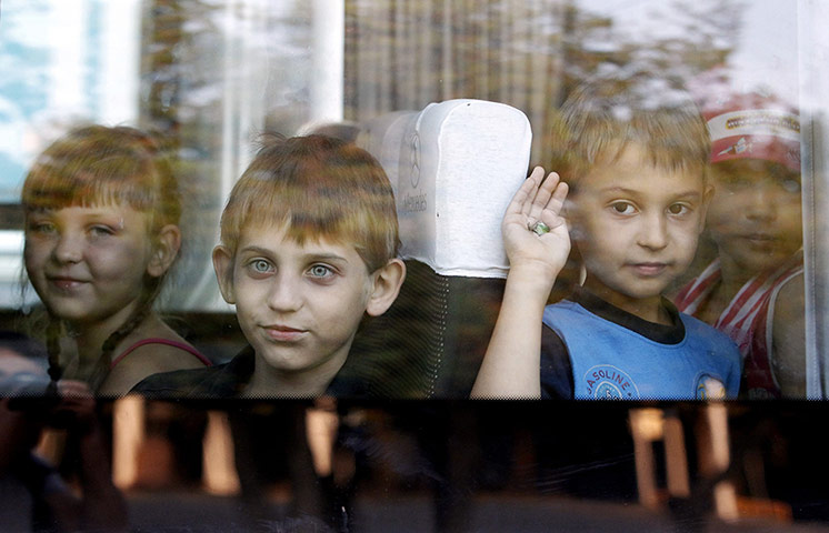20 Photos: Children who fled the fighting in Ukraine look out of the window of a bus