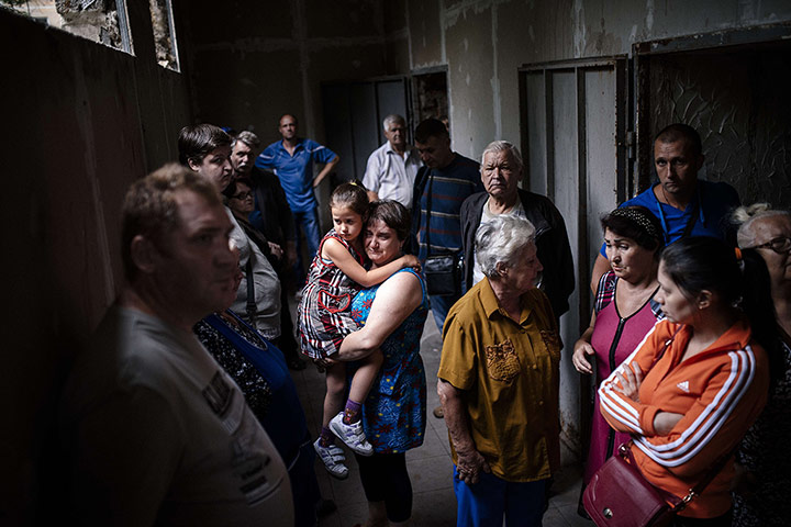 20 Photos: People stand inside a makeshift bomb shelter in Makiyivka, Ukraine