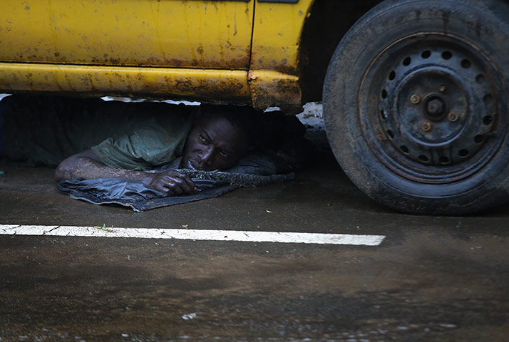 20 Photos: A man under a car detained by the Liberian army during the Ebola quarantine