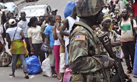 Liberia soldier scans people for signs of Ebola infection as part of quarantine measures in Monrovia