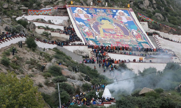 Pilgrims and tourists gather to view a giant Sakyamuni Buddha painting after its unveiling on a hill to celebrate the Sho Dun Festival at Drepung monastery in Lhasa city, Tibet.