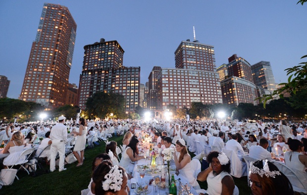 'Diner En Blanc' pop-up picnic at Rockefeller Park in New York - guests are of the location at the last minute and are required to dress in white, bring a picnic basket of food, fine china and silverware, white tablecloths, table and chairs