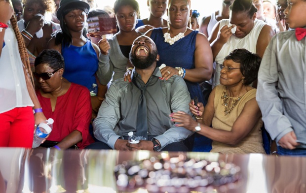 Michael Brown Sr. yells out as the casket is lowered into the ground during the funeral for his son Michael Brown at St. Peters Cemetery in St. Louis Missouri