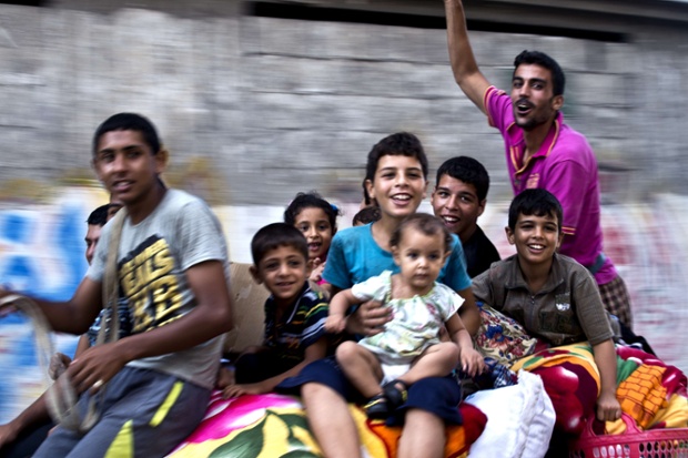 A Palestinian family ride on top of a horse cart as they head home with their belongings in the Shejaiya neighborhood in Gaza