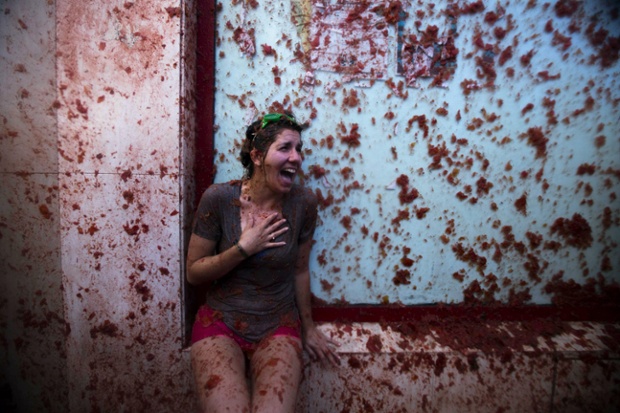 A woman reacts as she takes part in the traditional tomato fight Tomatina in Bunol, Spain