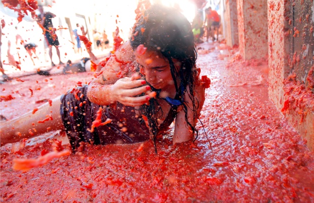 A woman lies in a puddle of tomatoes