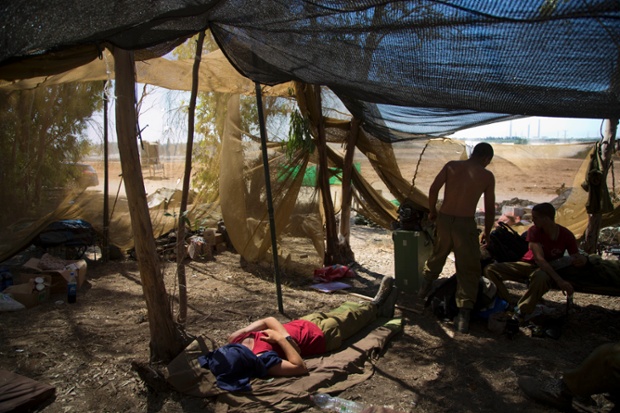 Israeli soldiers rest in an army staging area next to the Israeli Gaza border, after an open-ended cease-fire between Israel and Palestinian militants in the Gaza Strip was announced.