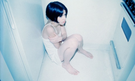 Cold child sitting by oven.