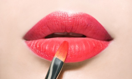 woman applying lipstick to lips
