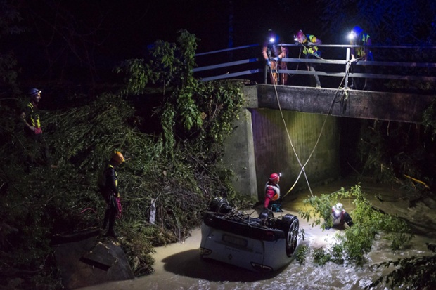 Rescuers search for a missing person inside a car swept away by floods near Treviso, northern Italy