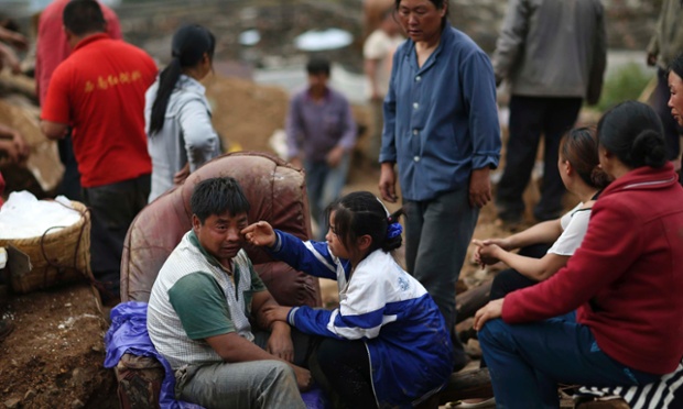 Liu Jiali (front L) cries as his daughter (C) wipes his tear after an earthquake killed Liu's wife and two other children in Longtoushan township of Ludian county, Yunnan province August 4, 2014. A magnitude 6.3 earthquake struck southwestern China on Sunday, killing at least 398 people in a remote area of Yunnan province, and causing thousands of buildings, including a school, to collapse.
