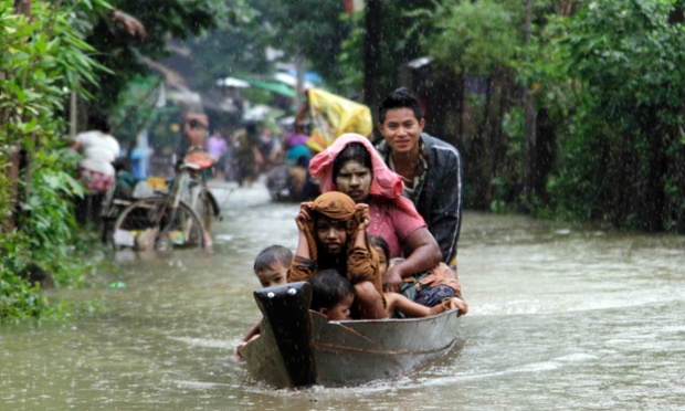 Local residents ride a boat on a flooded road overflown by the Bago river at a low-lying part in Bago, 80 kilometers (50 miles) northeast of Yangon, Myanmar, Monday, Aug. 4, 2014.   Flooding is common during Myanmar's monsoon season, which typically starts in late May and ends in mid-October.