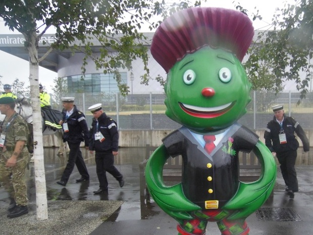 'Clyde's Army: Games mascot Clyde the Thistle flanked by Royal Navy and Army officers'