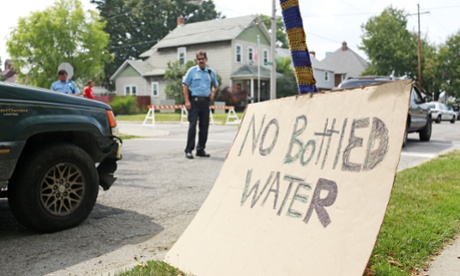 Toledo police officers direct traffic near a water distribution point at Waite High School in Toledo, Ohio. bottled water