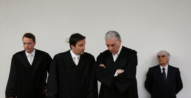 Formula One boss Bernie Ecclestone, right, waits besides his lawyers for the start of his trial in the regional court in Munich, southern Germany, Tuesday, Aug. 5, 2014. German prosecutors said Tuesday that they will accept dropping the bribery case against Bernie Ecclestone in exchange for a $100 million payment by the Formula One boss, and judges were considering whether to close his trial. Ecclestone went on trial at the Munich state court in late April on charges of bribery and incitement to breach of trust   which could, if he were convicted, carry a sentence of up to 10 years in prison.