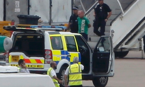 A man is escorted off a Qatar Airways aircraft by police at Manchester airport. The man was arrested over a bomb hoax threat after military jets escorted the plane into Manchester airport