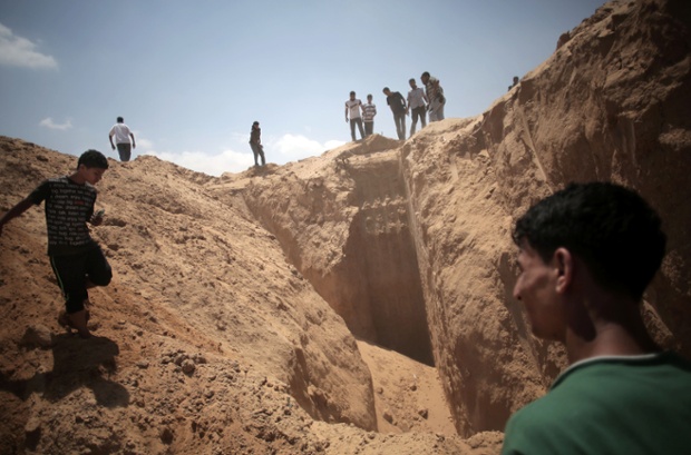 Palestinians inspect a what they think were excavations made by an Israeli drill designed to uncover tunnels used by Palestinian militants, in Shawkah.