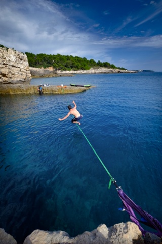 A climber walks over a Slackline in Stoja, Croatia