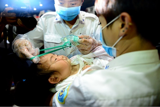 An oxygen mask is placed on a baby injured in the earthquake in Kunming, China