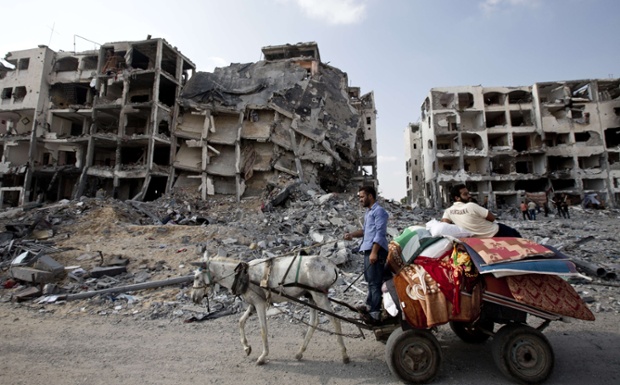 Palestinian men ride a donkey cart past destroyed buildings in the northern Gaza Strip.
