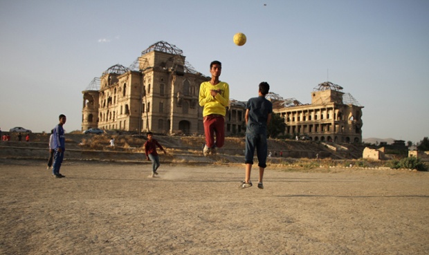 Boys play with football beside the war-ravaged Dar-ul-Aman palace, on the outskirts of Kabul, Afghanistan