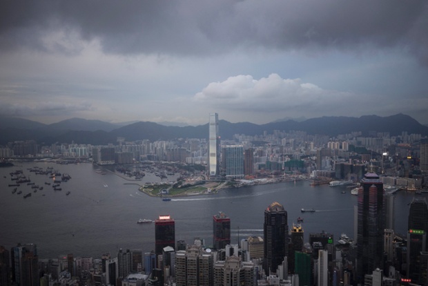 Dark clouds over residential and commercial high-rise buildings on Hong Kong island and Victoria Harbour on the Kowloon Peninsula in Hong Kong