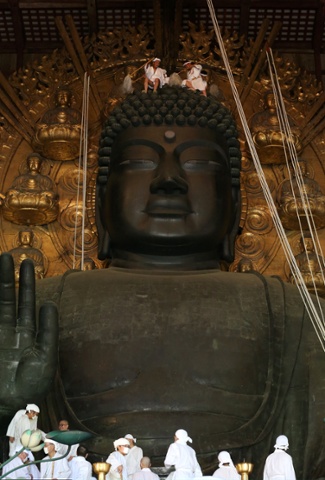 Buddhist monks clean the 15-meter-high Great Buddha at the Todaiji Temple in Nara, Japan