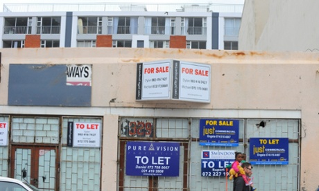 All over Woodstock there are premises for sale or to rent, with many once housing local businesses unable to afford the increased rents. In the background is one of the new, upmarket blocks of flats that have sprung up to accommodate people moving into the area, a sign of the growing gentrification taking place. For Cities: gentrification of Woodstock. Cape Town, South Africa