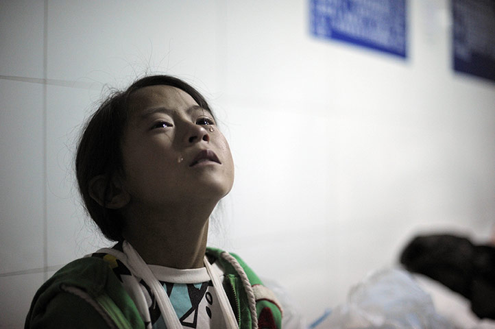 20 Photographs: An injured girl cries at Ludian hospital after the earthquake