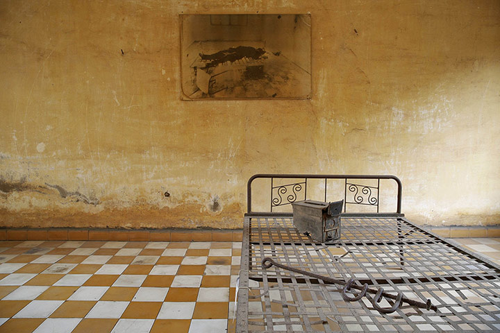 20 Photographs: A photograph hangs in a room once used as a torture chamber, Phnom Penh