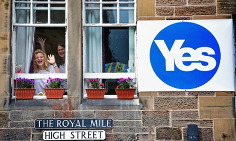EDINBURGH, SCOTLAND - SEPTEMBER 09: Two women wave from a window of a property on the Royal Mile on September 9, 2014.