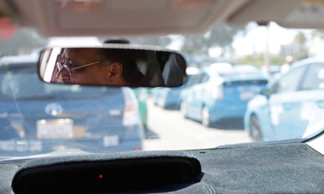 Cab driver Daniel Afeweki looks out from his Toyota Prius cab as he waits in line for his turn to pick up fares at the San Diego airport.