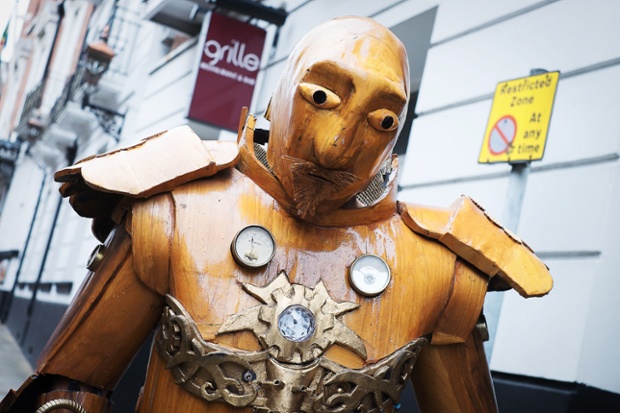 A man wearing an automaton costume made entirely out of carved wood