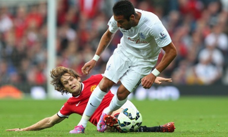 Mauricio Isla of QPR loses out to a sliding challenge by Manchester United's new Dutch international, Daley Blind