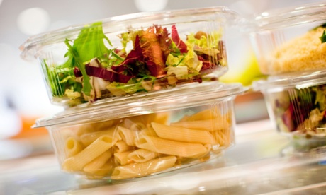 food packaging stacked on top of one another, containing salad and pasta