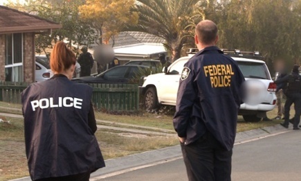 Australian federal police officers arrest two men in Brisbane last week. Photograph: Australian federal police/AFP/Getty Images