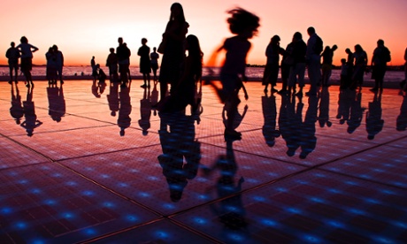 Children playing on the monument to the sun, a solar panel art installation in Zadar, Croatia.