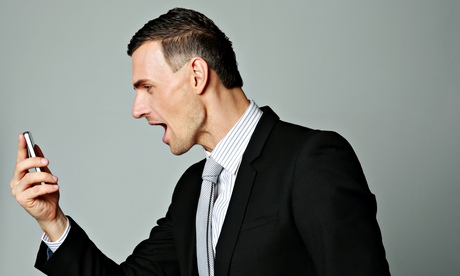 Angry businessman shouting at his smartphone