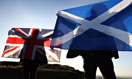 people holding a scottish and british flag