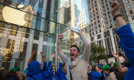 Local resident Andreas Gibson celebrates with employees outside the Fifth Avenue Apple store after being the first to exit with an iPhone 6 in hand on the first day of sales in Manhattan, New York