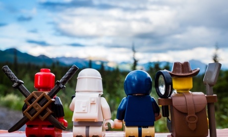 the backs of lego figures against a landscape background