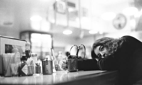 A young woman drinks a cup of coffee.