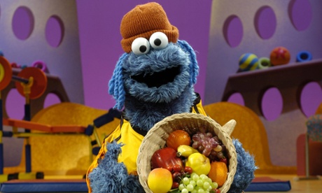 cooking monster from sesame street holding fruit basket